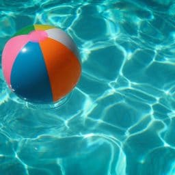 A colorful beach ball floats in a pool.