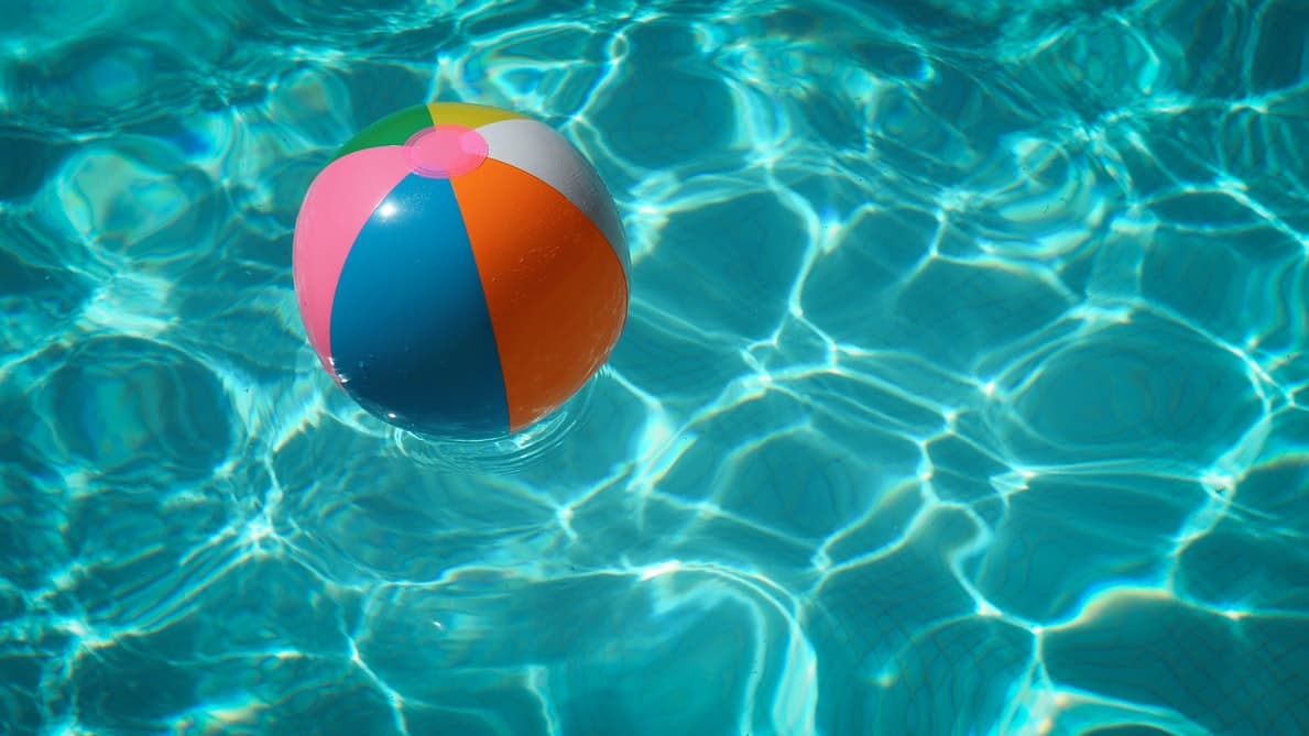 A colorful beach ball floats in a pool.