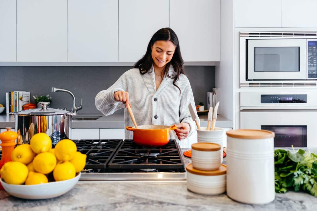 Smiling woman cooking at home.