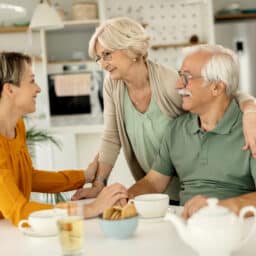 Woman visiting her senior parents and communicating with them at home.