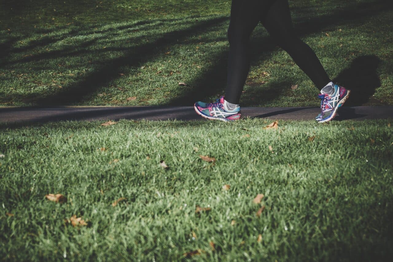 Close-up of woman jogging through a park.