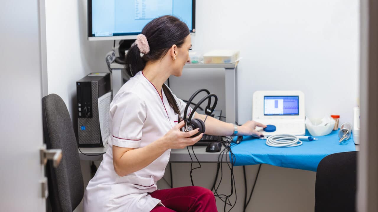 Audiologist setting up a hearing test.