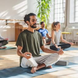 Calm man meditating in a yoga class