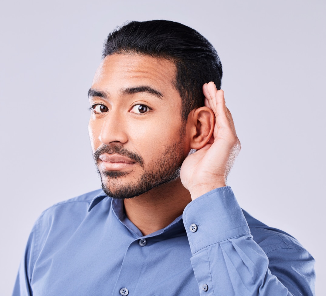 Man holding his hand to his ear.