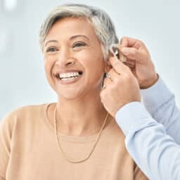 Happy woman getting a new hearing aid