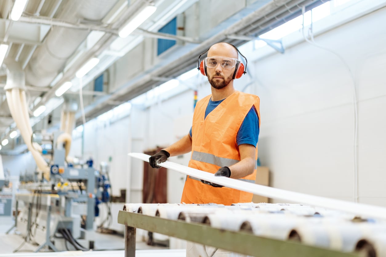 Production line worker wearing earmuffs.